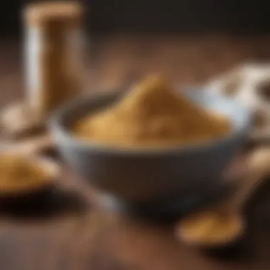 Ginger powder in a bowl with a wooden spoon for dosage